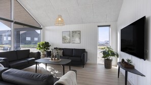 A modern living room with a sofa, coffee table, and TV. - VillaVilla 907 - Skåstrup Strand, Fyn og øer (Bogense)