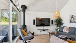 Un salon chaleureux avec une cheminée, un téléviseur à écran plat, un canapé confortable et une table à manger.