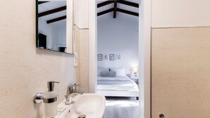 A bathroom with a sink, mirror, and toilet paper holder. - Near the lake and the center (FLORIDA ASCONA Room 14) (Ascona)