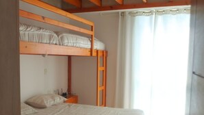 A bunk bed room with a wooden ceiling and a white bedspread. - HOP Aloha Beachfront House With Direct Access (Chincha Baja)