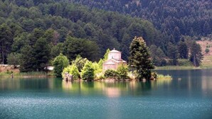 Ein kleines Gebäude, umgeben von Bäumen und einem See.