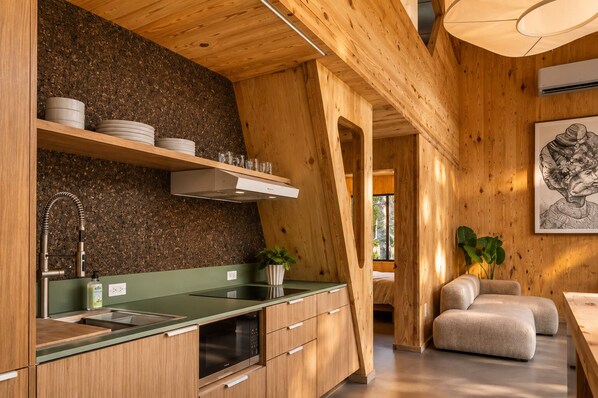 A modern kitchen with wooden cabinetry, a green countertop, and a built-in oven.