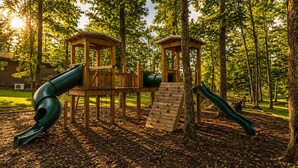 Une aire de jeux avec un toboggan, un mur d’escalade et des tours d’observation.