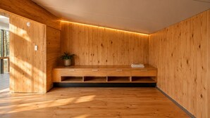 Une pièce moderne avec des murs lambrés en bois, un banc intégré doté de tiroirs et une plante en pot.