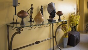 A glass-top table with various decorative items and a vase of yellow flowers. - CHARMING VILLA in SOMONE Private Pool, Beautiful Garden! Lagoon & Mangrove (Somone)