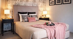 A neatly arranged bedroom with a large bed, two bedside tables, and a nightstand. - Il Melograno in Prato with Private Guest Parking and Terrace (Prato)