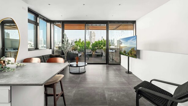 Un intérieur moderne comprenant un coin repas, une grande fenêtre et une vue sur le paysage urbain.
