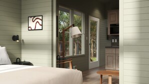 A bedroom with a bed, a nightstand, a lamp, and a window with a view of the outdoors. - Outbound Yosemite (Oakhurst)