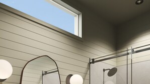 A modern bathroom with a wooden vanity, a large mirror, and a glass shower enclosure. - Outbound Yosemite (Oakhurst)