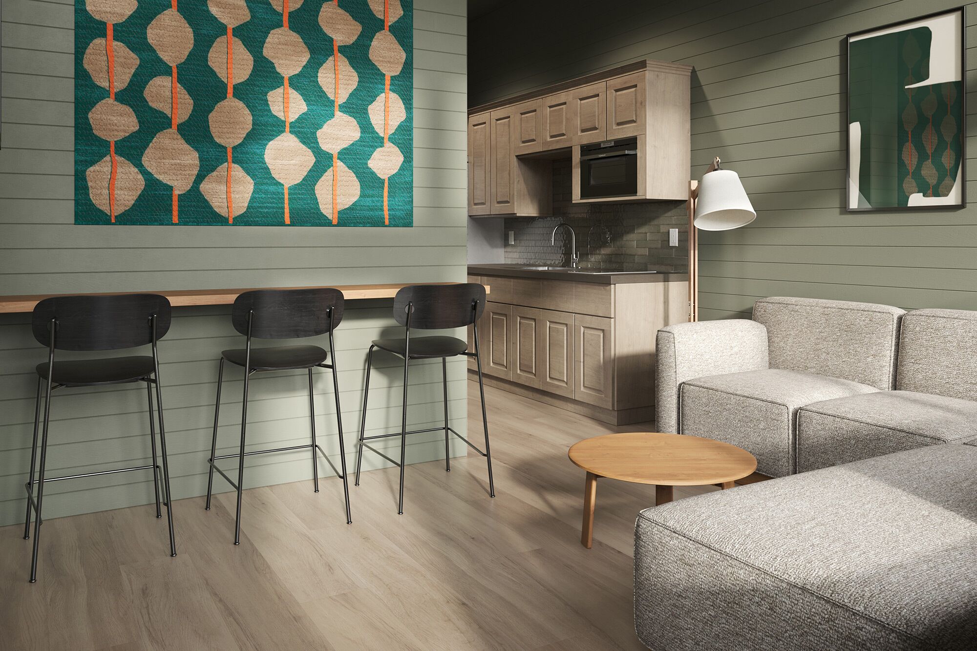 Une cuisine moderne avec des meubles en bois et un four encastré, un coin repas avec un canapé gris et deux chaises noires, et une décoration murale à motifs.