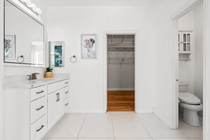 A modern bathroom with white cabinetry, a large mirror, and a wooden floor. - Luxury Hilltop Home Spacious Private Backyard (Rowland Heights)