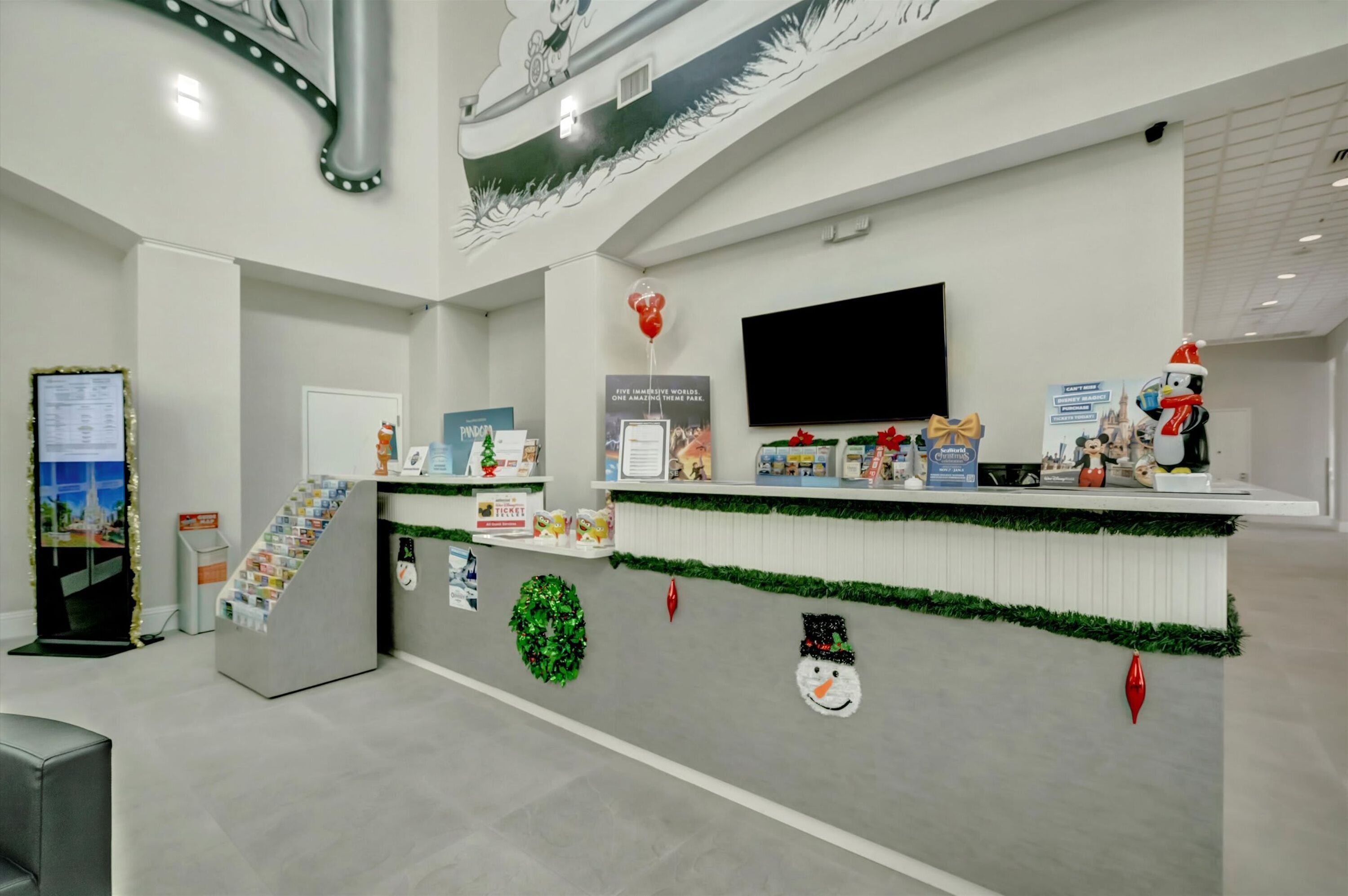 A reception area with a counter, a television, and holiday decorations.
