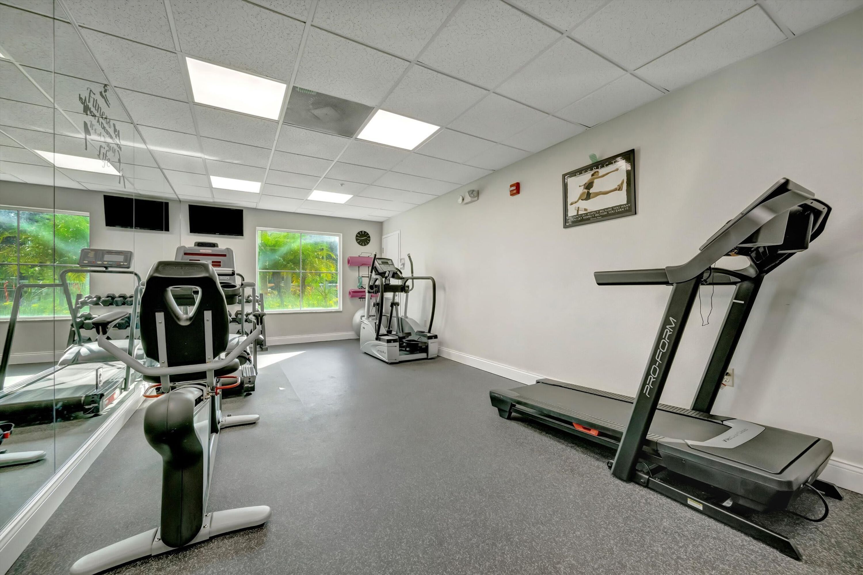A gym with cardio machines, weight machines, and a treadmill.