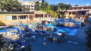 A swimming pool with lounge chairs and a wooden deck.