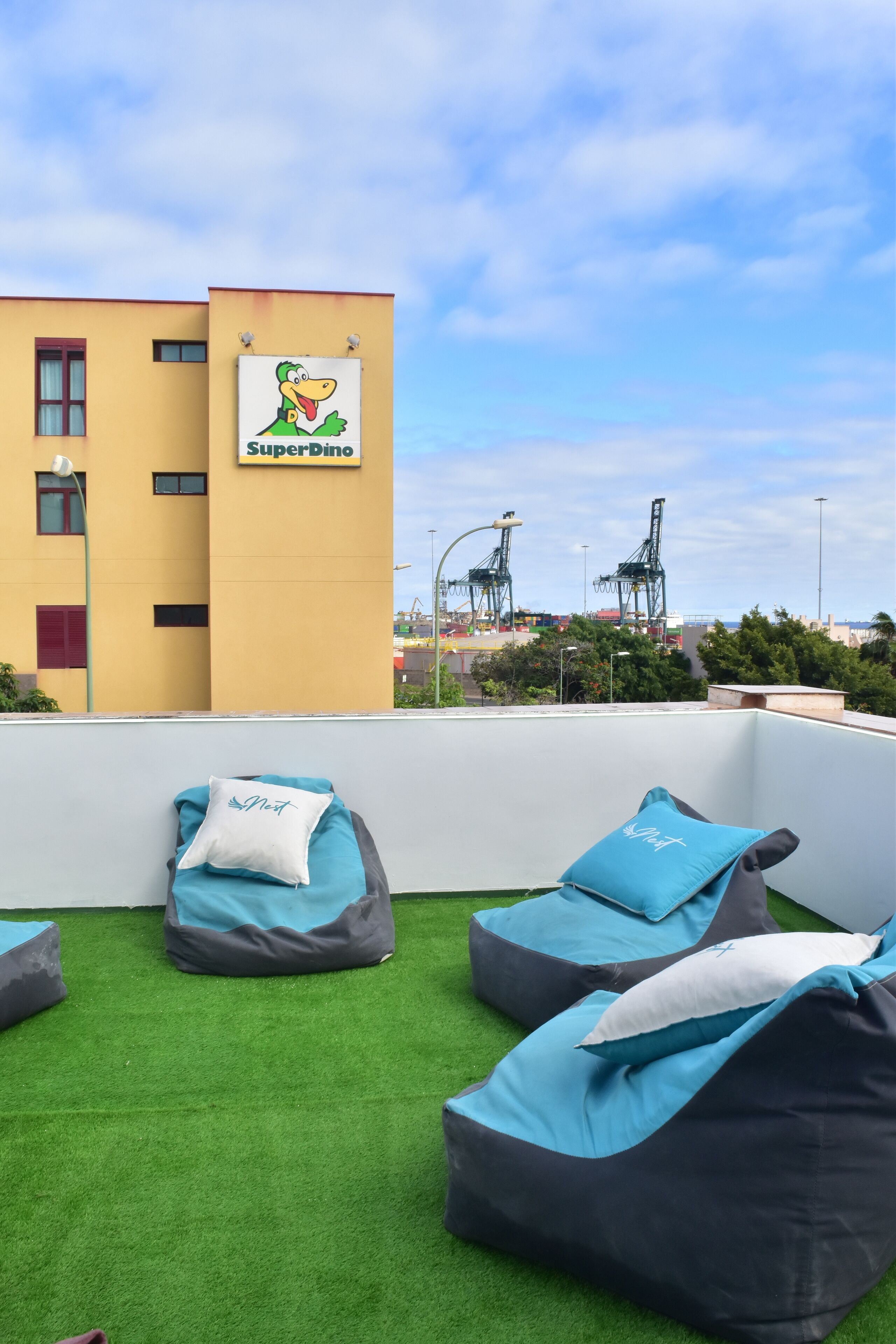 A rooftop lounge area with bean bags and a SuperDino sign.