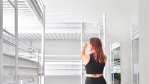 A bunk bed room with a person standing by the bed. - La Isleta Nest Hostel (Las Palmas de Gran Canaria)