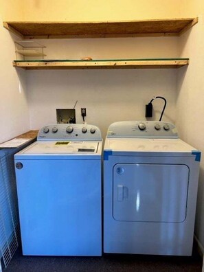 A laundry area with two washing machines and a shelf above. - Conquistador 8 Navarra Ct (St. Augustine)