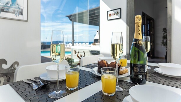 A table set with glasses of white wine, a bottle of Moët & Chandon champagne, and a glass of orange juice. - Puesta Del Sol (Montaña Roja)