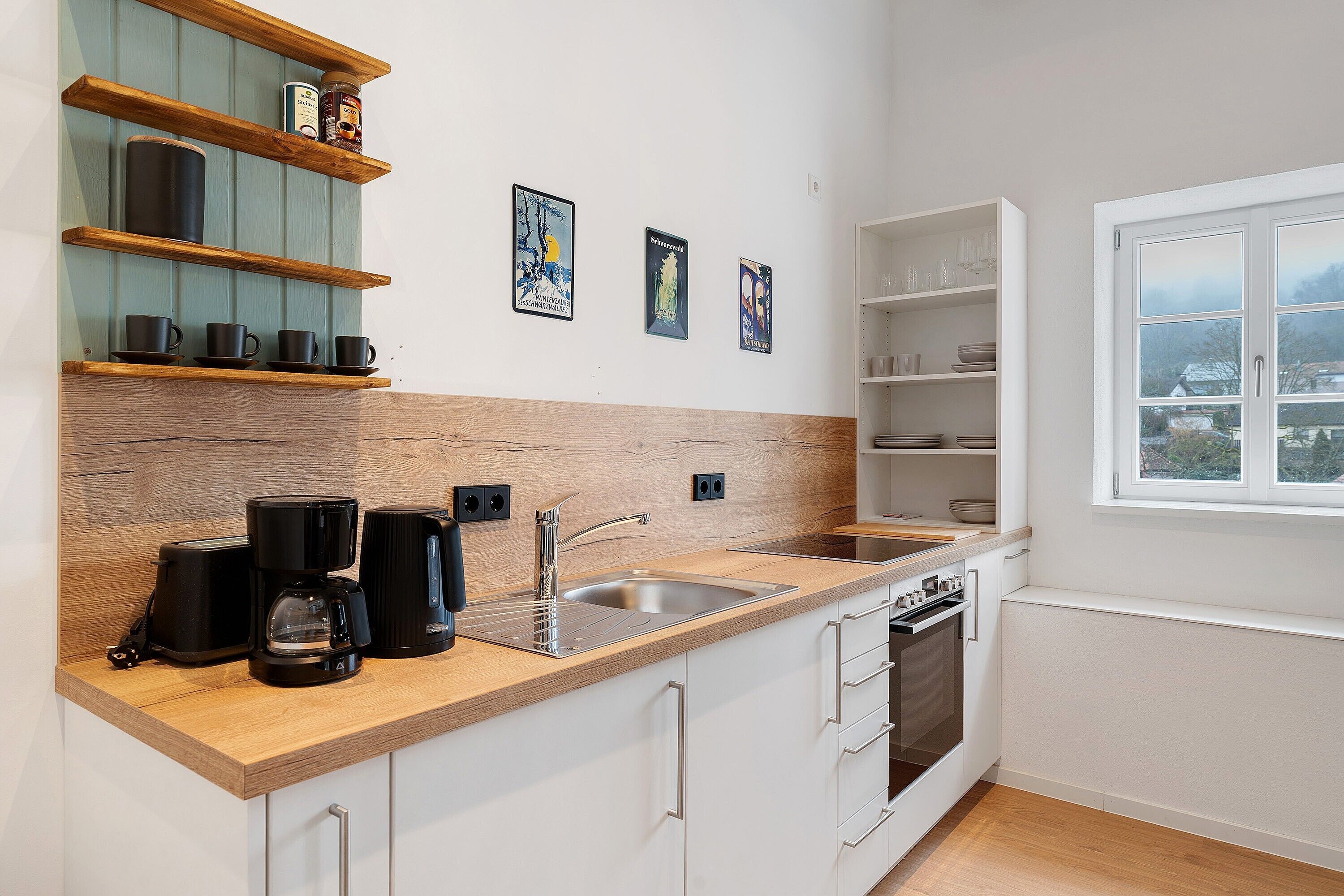 Una cucina moderna con piano di lavoro in legno, lavello incassato e finestra vista.