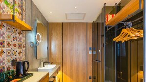 Une salle de bain moderne avec un meuble-lavabo en bois, un évier, un miroir et un espace douche doté d'une porte en verre.