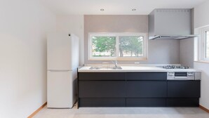 Een moderne keuken met een ingebouwde vaatwasser, een gasfornuis en een raam boven de gootsteen.