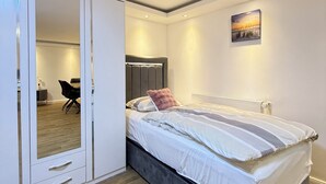 Een slaapkamer met een bed, een kledingkast en een schilderij aan de muur.