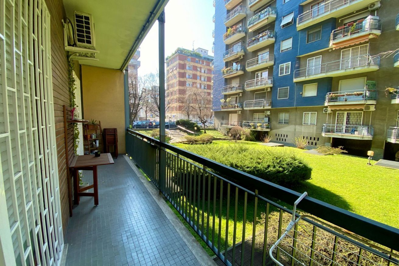 Ein Balkon mit Blick auf einen gepflegten Rasen und angrenzende Gebäude.