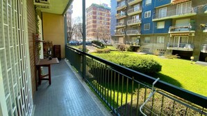 A balcony with a view of a well-maintained lawn and neighboring buildings. - GuestHost - M1 Gambara Balcony Studio (Milano)