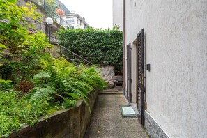 A narrow alleyway with a stone wall on one side and a building on the other. - GuestHost - Nice studio apartment located on the ground floor of a residential building with a shared garden (where you can park bicycles).Please note: it is not possible to park just outside the house. The closest parking (not guaranteed) is located in  (Como)