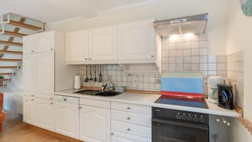 Una cocina con muebles blancos, un lavamanos de acero inoxidable, un lavavajillas Siemens y un horno Siemens.