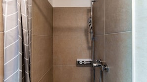 A shower with a handheld showerhead, a wall-mounted control panel, and a towel rack. - <p><strong>Near the lake and the center (FLORIDA ASCONA Room 12)</strong></p><p>Just a few steps from the center and the charming lakeside promenade of Ascona, FLORIDA ASCONA Room 12 welcomes guests into a refined and comfortable setting, ideal for disco (Ascona)