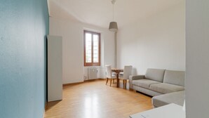 A spacious living area with a sofa, dining table, chairs, and a tall floor lamp. - GuestHost - Comfortable and bright 70m2 apartment, for 4 people, located on the 3rd floor of a building with elevator (NOT SUITABLE FOR DISABLED GUESTS). The property is located in the Isola neighborhood, very young and full of services, well served by p (Milan)