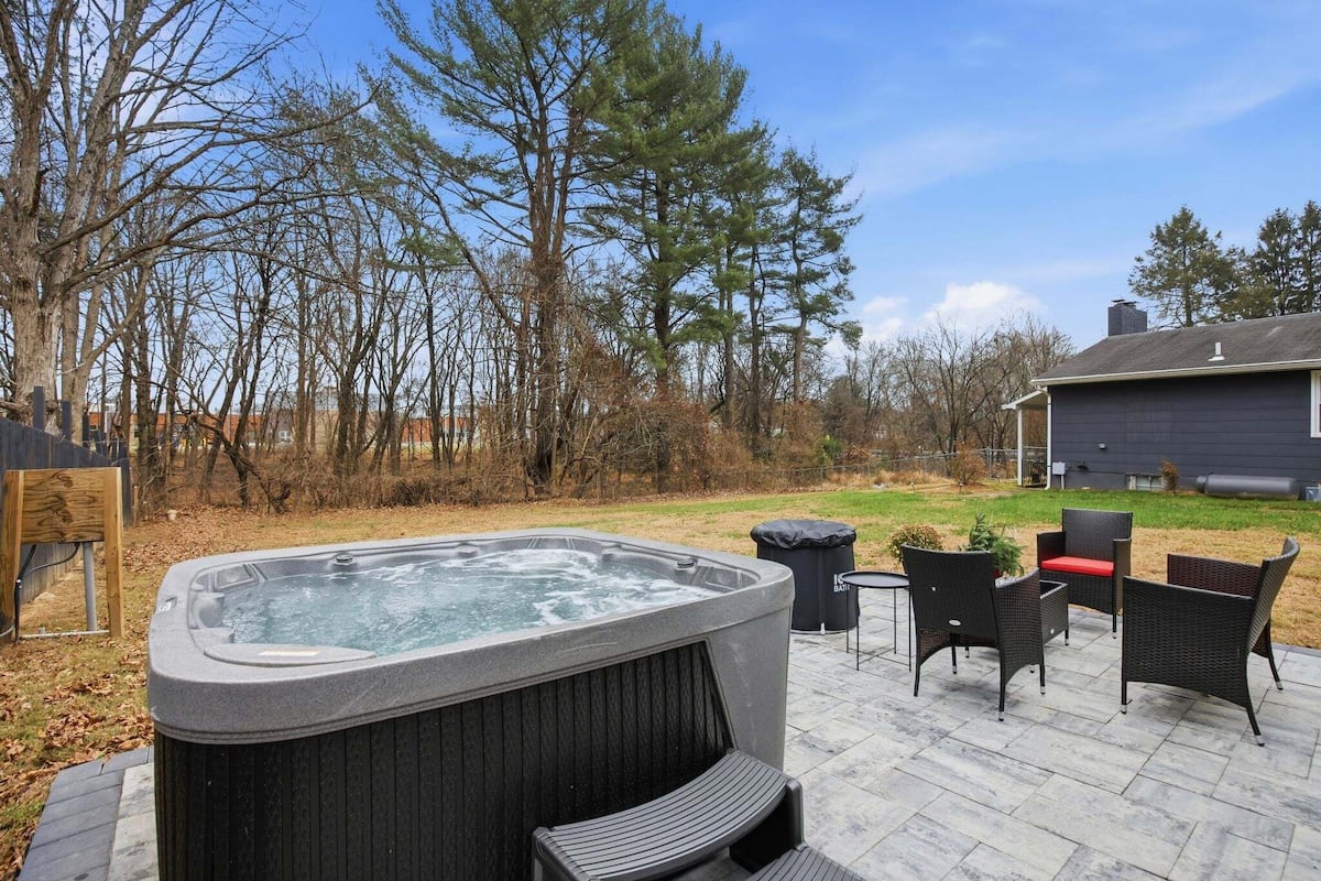 Un bain à remous avec une terrasse en bois et du mobilier d’extérieur.