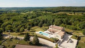 A large house with a swimming pool, surrounded by lush greenery and hills in the background. - Villa Ovi (Karojba)