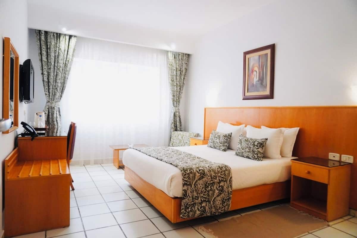 Una habitación de hotel con una cama grande, un escritorio y una silla.