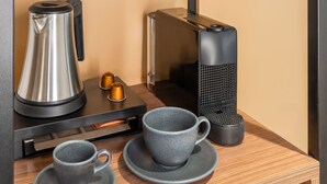 A modern kitchen with a coffee maker, two cups, a kettle, and a decorative deer figurine on a shelf. - OLIVER pulse I Self check-in Apartments (Vienna)