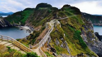 A coastal road with a bridge leading to a cliffside.