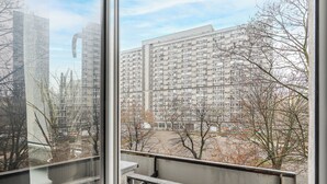 A view of a multi-story residential building with balconies and a parking area visible in the foreground. - Lumina Cozy apartment near the center (Warsaw)