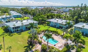 Ein Resort mit mehreren blauen Gebäuden, einem Schwimmbad und üppiger Vegetation.