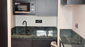 Frigorífico pequeño, microondas, placa de cocina y utensilios de cocina