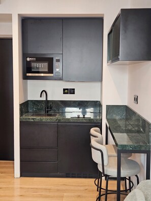 Frigorífico pequeño, microondas, placa de cocina y utensilios de cocina