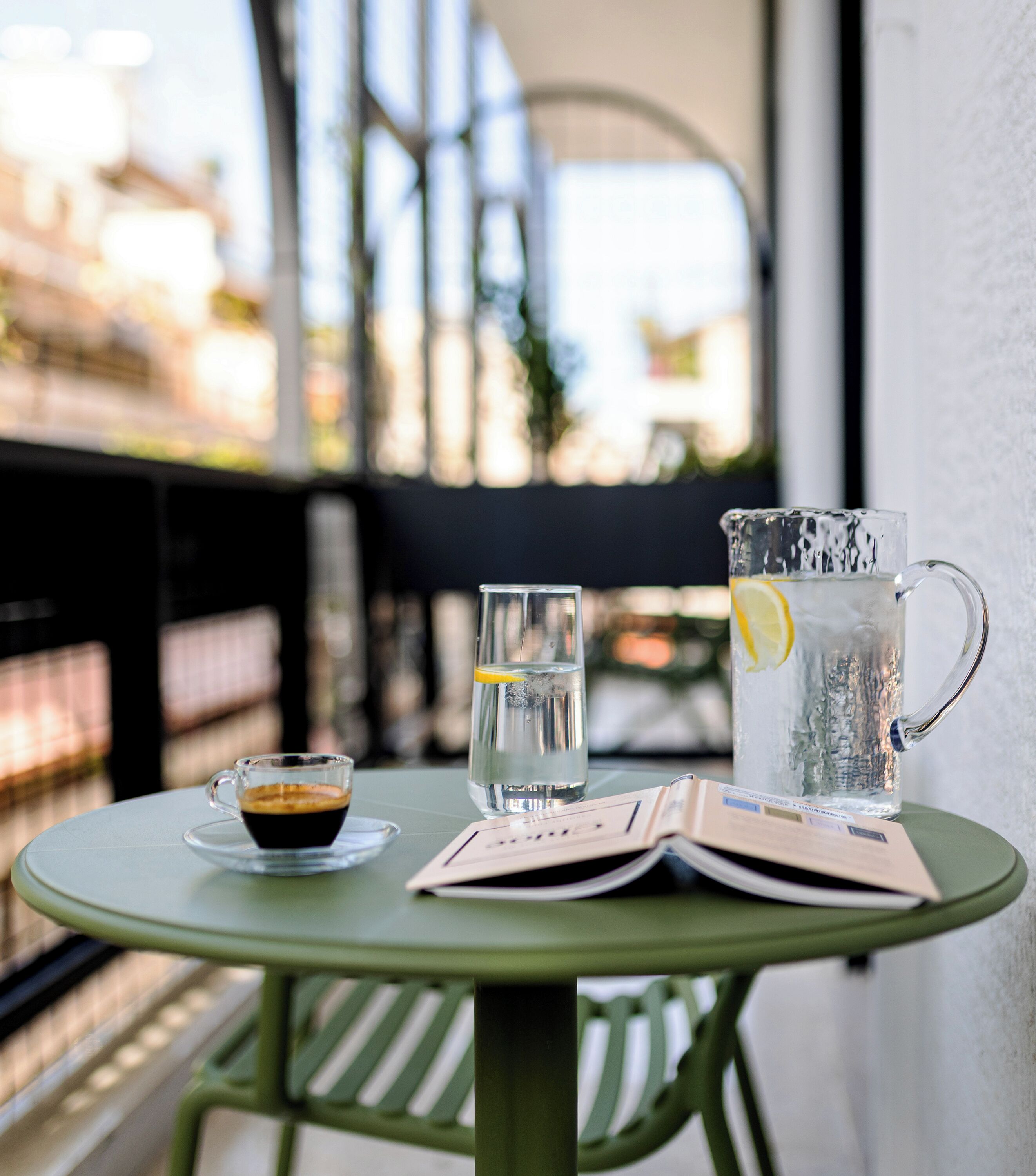 Una mesa con una jarra de agua, un vaso de agua y una taza de café.