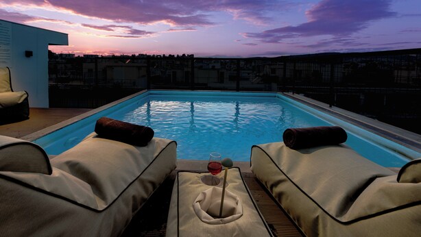 A rooftop pool with lounge chairs and a glass of wine. - Zea Urban Living (Piraeus)