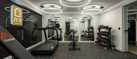 A fitness area with treadmills, an elliptical, and a weight rack.