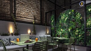 A modern indoor seating area with a laptop, notebook, and drink on a table, surrounded by chairs. - Zea Urban Living (Piraeus)