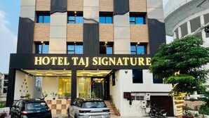 A modern hotel building with a prominent sign reading "HOTEL TAJ SIGNATURE". - Hotel Taj Signature (Agra)