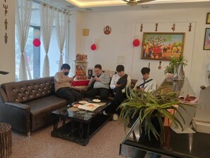 Ein Wohnzimmer mit einem braunen Sofa, einem Glastisch und einer Topfpflanze.