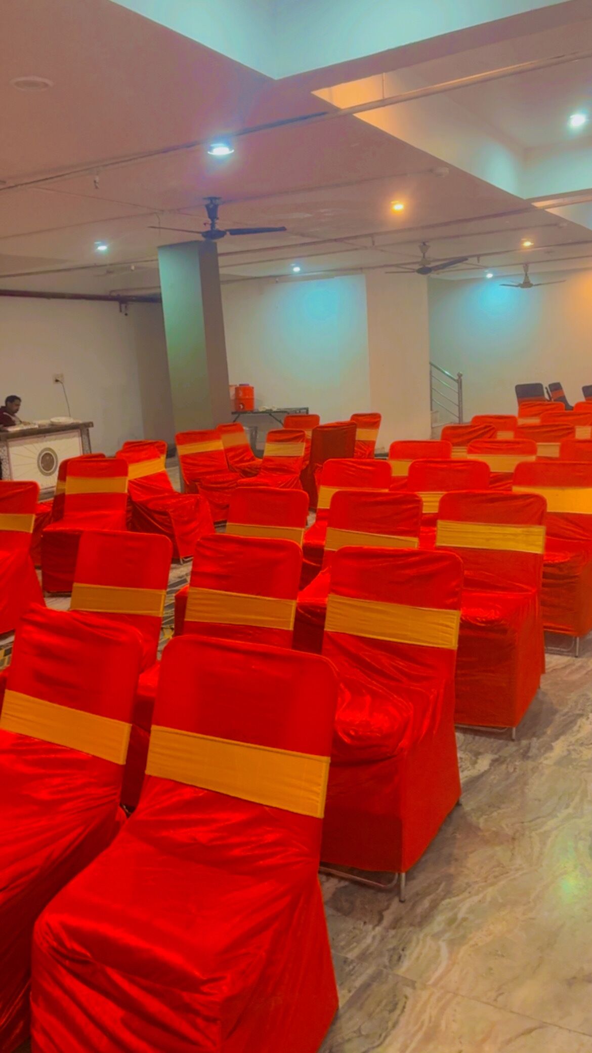 A conference room with rows of chairs covered in red and yellow.