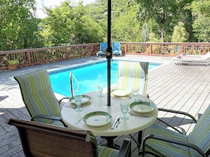A poolside dining area with a table set for two, surrounded by chairs, and a pool in the background. - Relax & Recharge in Meridian – 2BR Home w/ Private Pool (St John)