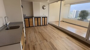 Una cocina moderna con un lavamanos, un espejo redondo y suelo de madera.